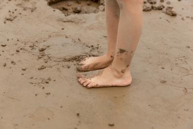 站在沙泥地上沾满泥巴的小朋友的脚