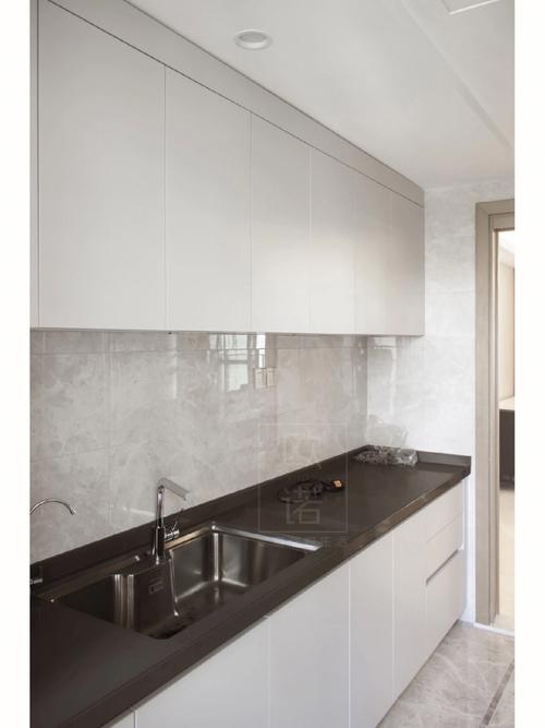 90图1-3厨房橱柜暖白色的厨房搭配黑色的台面将部分自然采光引入