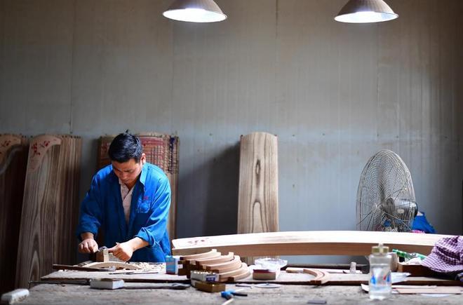 在河南省兰考县堌阳镇大河乐器厂,工人袁排朵在制作古筝(9月4日 新华