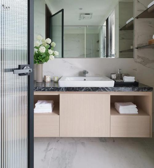 卫生间的洗手盆以台上盆的设计,结合木质洗手盆柜,还有大尺寸的镜子