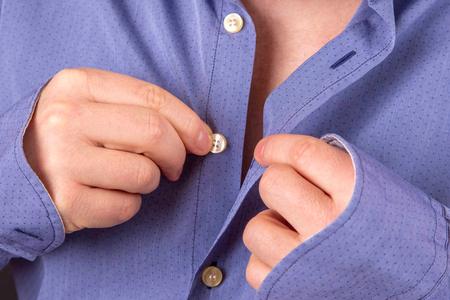 系扣子的衬衫男人把扣子系在衬衫上照片