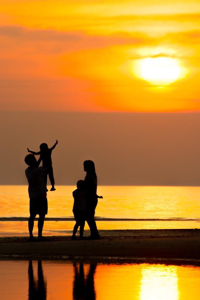 海滩上的家人,家庭在日落海滩上的剪影.