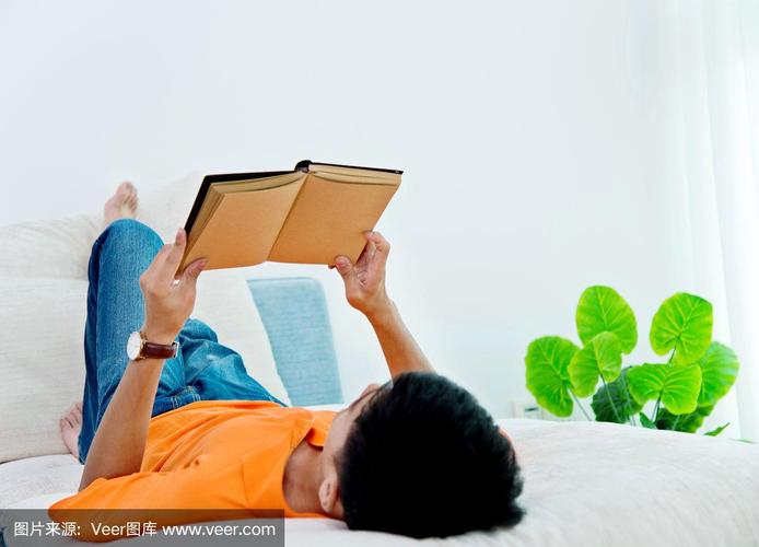 一个年轻的亚洲人在家里看书
