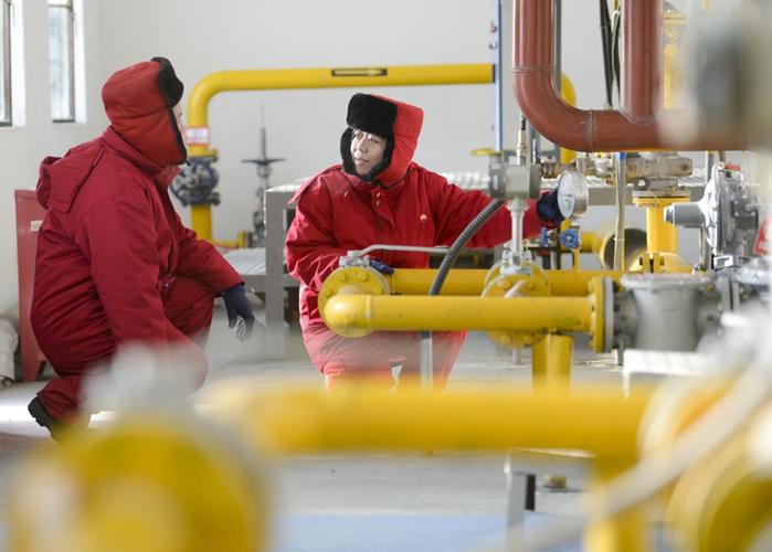 在新疆油田公司油气储运公司总站里,工作人员陈宇(右)和桂勇在对加热