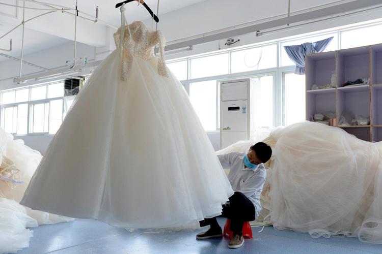 4月30日,工作人员在安徽六安市丁集镇的一家婚纱生产企业内缝制