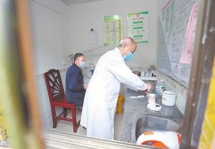 在铜鼓县高桥乡白石村,乡村医生杨福盛出门巡诊,为行动不便的村民送医