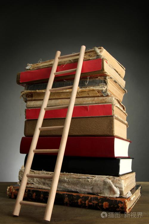 古老的书籍和木梯子灰色的背景上