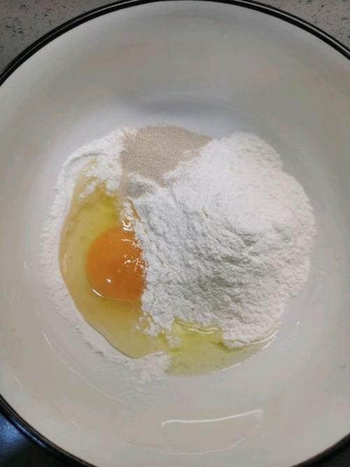大碗里倒入300g面粉,打入1个鸡蛋,3g酵母,1g小