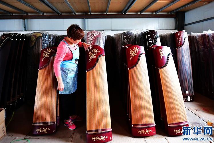 河南省兰考县大河乐器厂工人何素英正在检查即将销售的古筝(9月4日