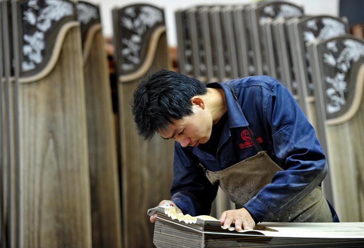 10月18日,肃宁县一家民族乐器厂的工人在生产车间制作古筝.
