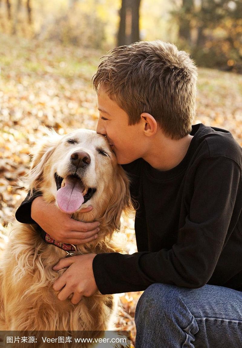 微笑的小男孩亲吻他的狗