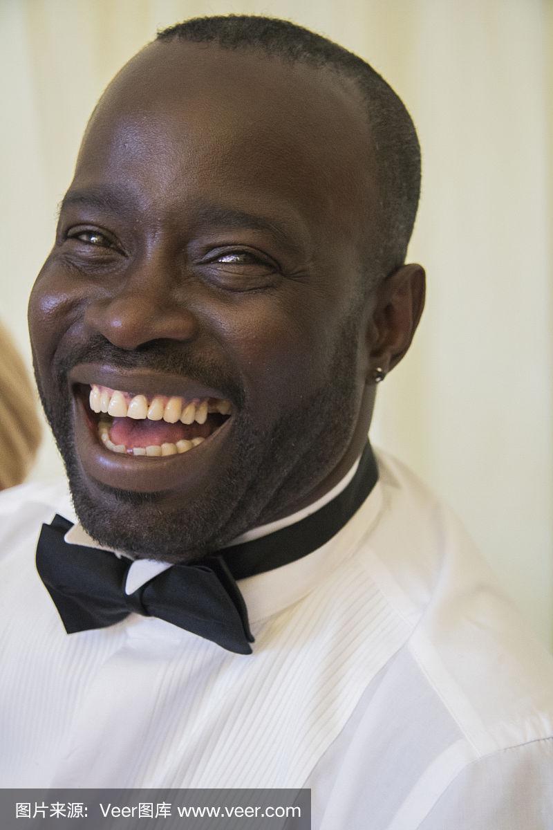 一个穿着黑色领带的大笑的加勒比黑人男性的肖像