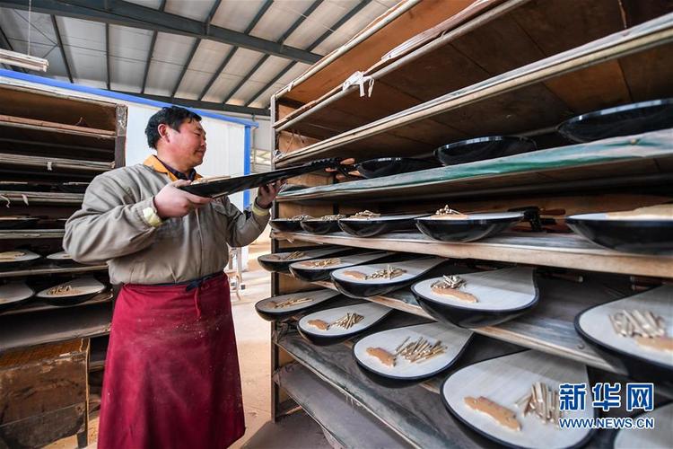 在河南省兰考县一家乐器厂,工人在车间里整理准备加工的乐器(3月9日摄
