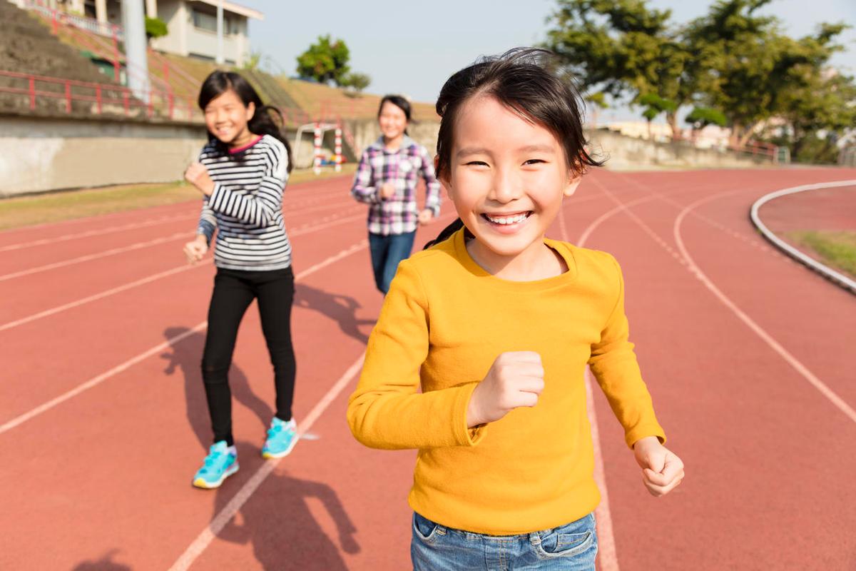 快乐的小女孩在操场跑道上奔跑幸福的人美好校园美好童年美好未来儿童