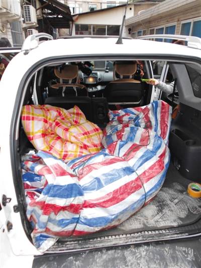 老虎被装在一个蓝白红相间的编织袋里,搬运到一辆白色丰田越野车上.