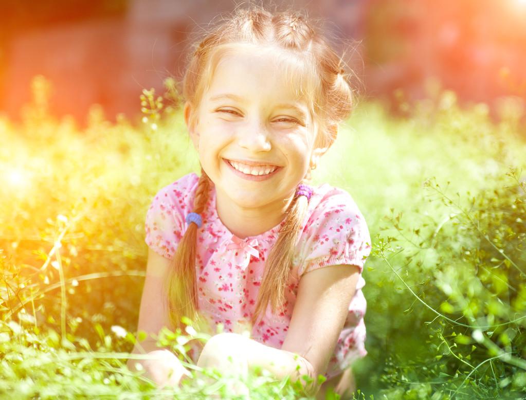笑笑的小女孩,可爱的微笑女孩在阳光灿烂的夏天一天在草原上