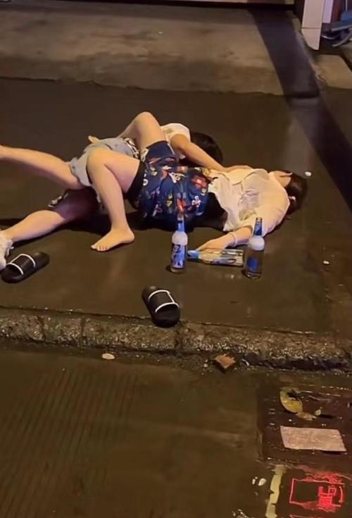 两女子喝醉酒可能把马路当成床躺在路中间翻来翻去不愿起来