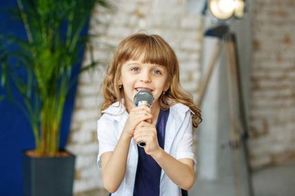 一个漂亮的小女孩用麦克风唱歌.概念是 ch照片