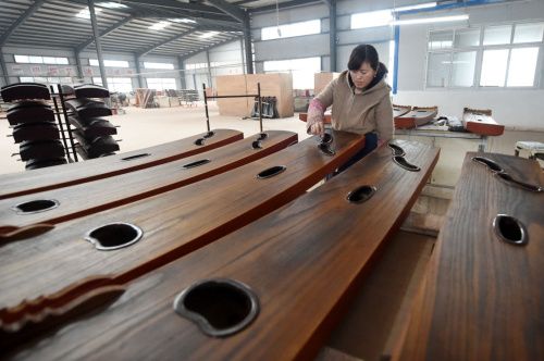 4月6日,河南兰考县一家乐器厂的工人在车间里制作古筝.