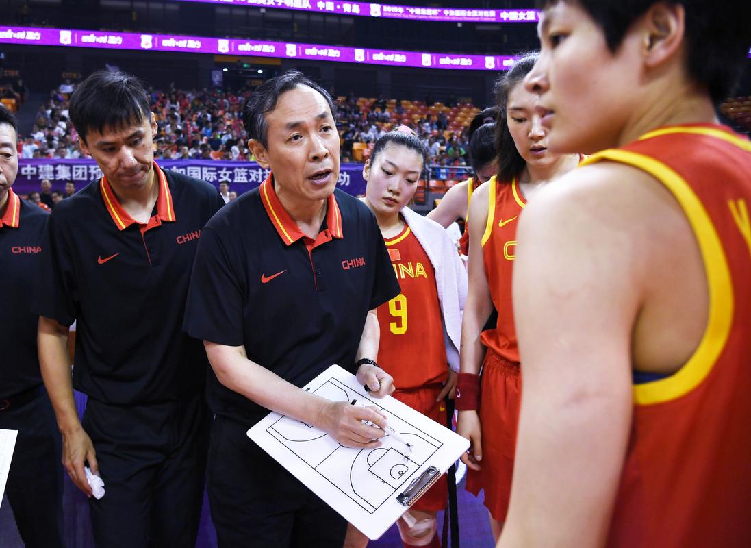 中国女篮主教练许利民(中)在比赛中布置战术.