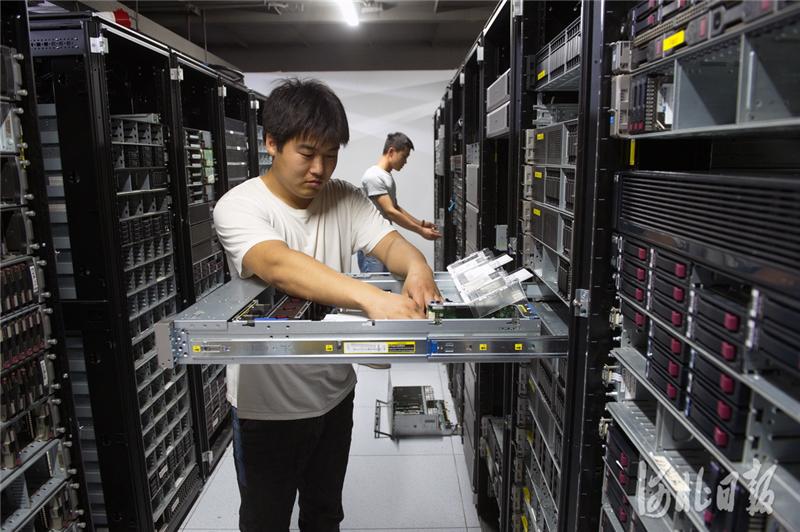图为展旭(三河)科技有限公司的工作人员正在对服务器进行维护组装
