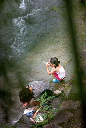 在河边玩水的小女孩