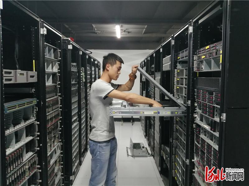 图为展旭(三河)科技有限公司员工对服务器进行日常维护.