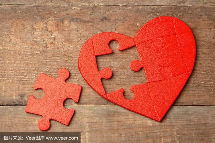 木制背景上的红色心形拼图.概念另一半的心因情人节或生病而陷入爱河