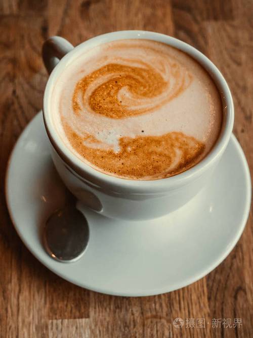 一杯漂亮的卡布奇诺咖啡背景是拿铁艺术最小成分为文本复制空间