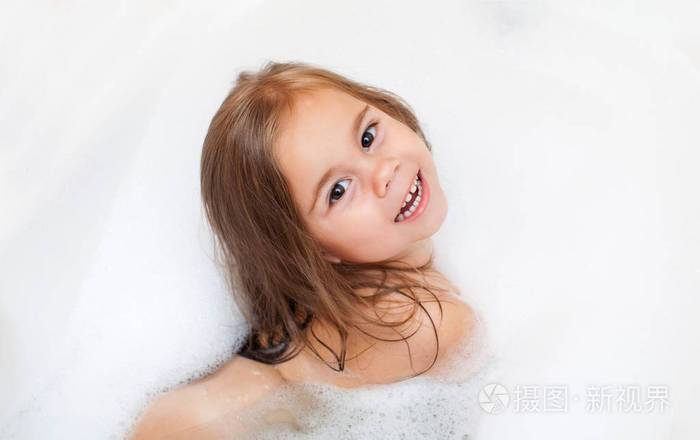 快乐的小女孩正在洗澡的泡沫