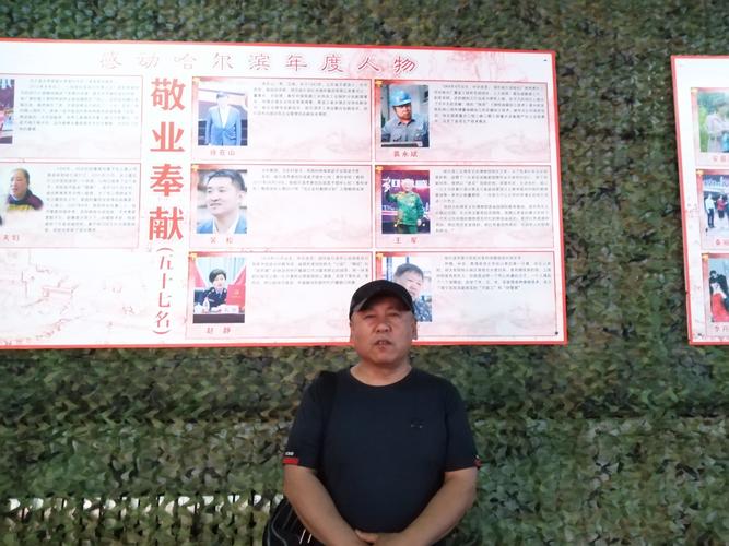 2018年感动哈尔滨年度人物裴永斌在自己的人物介绍展板前合影留念