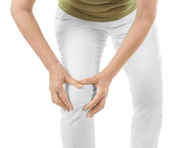 老年妇女患在白色背景上的膝盖疼痛照片