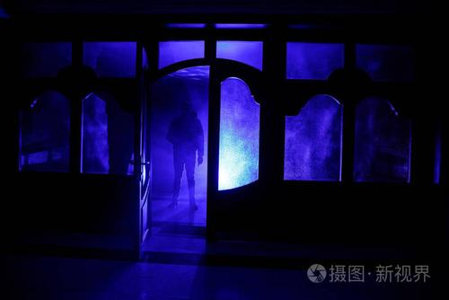 一个未知的影子身影在门通过一个封闭的玻璃门的剪影.