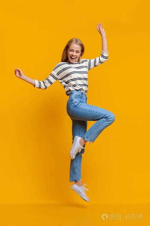 积极向上的美丽少女举起双手在空中跳跃