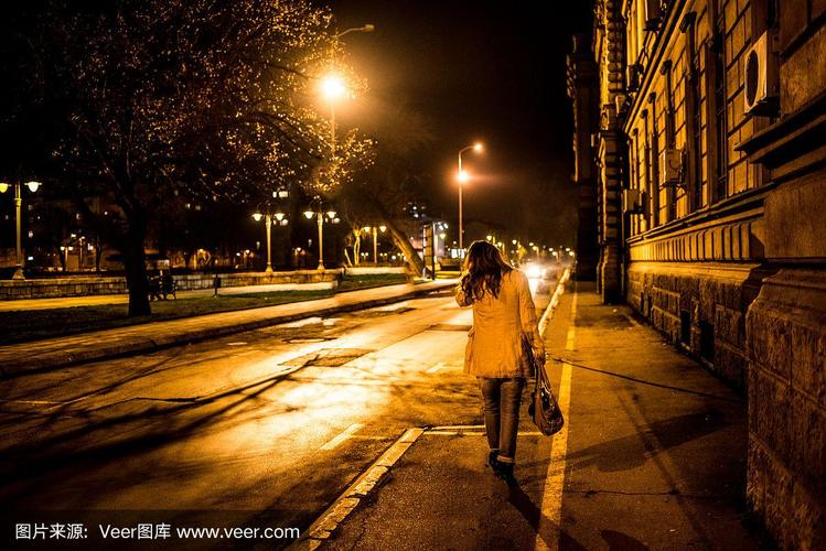 一个年轻女子走在夜晚的城市里