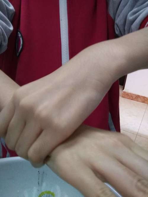 (6)伸出一只手,另外一只手握住那只手的手腕处旋转摩擦.