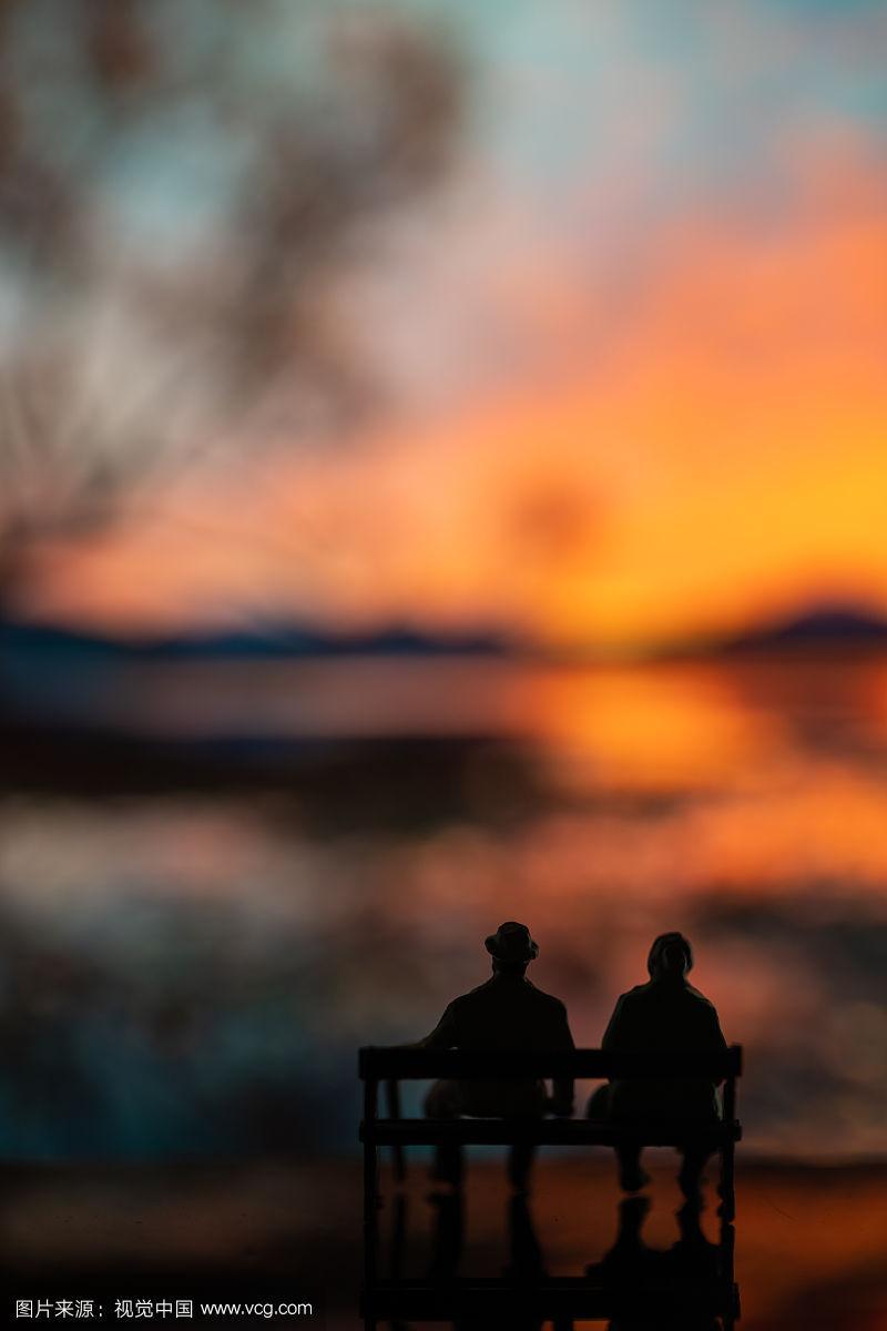 夕阳下坐在长椅上的老夫妻