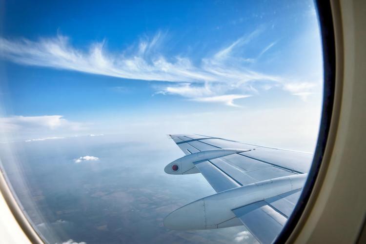 晴朗的蓝天在机翼飞行的过程中透过窗户看飞机飞机旅游