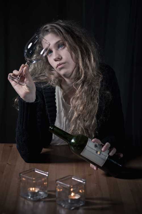 喝酒的年轻女人图片-坐在桌子旁边倒酒的女人素材-高清图片-摄影照片