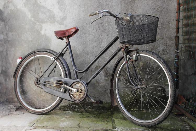 旧自行车,在一个破旧的背景的旧自行车
