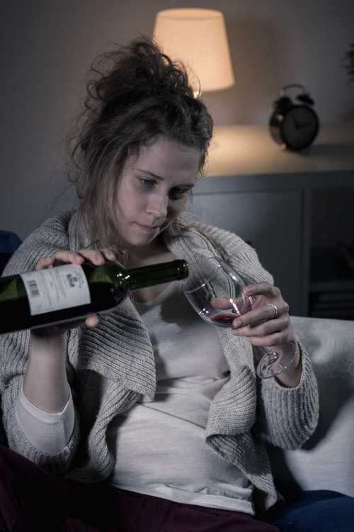 喝酒的年轻女人图片-坐在桌子旁边倒酒的女人素材-高清图片-摄影照片