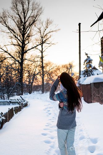 年轻漂亮的女人 (女孩) 玩雪在暖和的衣服微笑在公园里