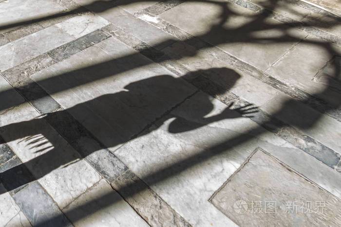 一个女人在石头地板上的影子