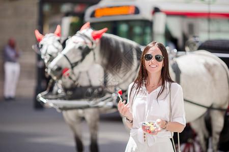 荐客有礼维也纳有街头食物的年轻女青在马车背景中有漂亮的马匹美丽