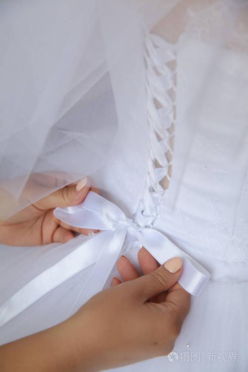 新娘.蕾丝婚纱礼服.母亲把婚礼紧身衣绑起来.特写