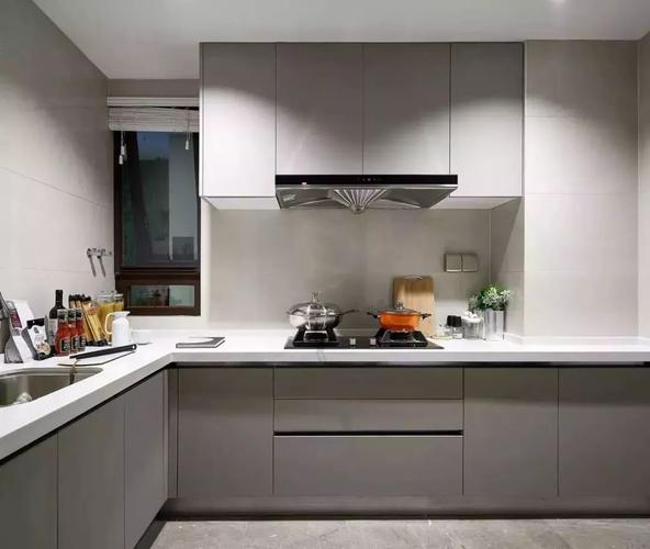 厨房内部用灰色调的柜子和地砖来搭配白色的墙面,台面.