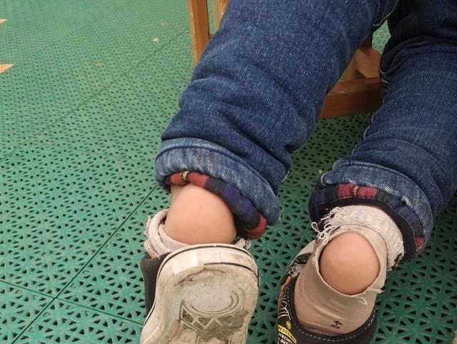 小男孩每天上学都会穿着一双很小的鞋子,时间一久,脚跟处的袜子就磨出