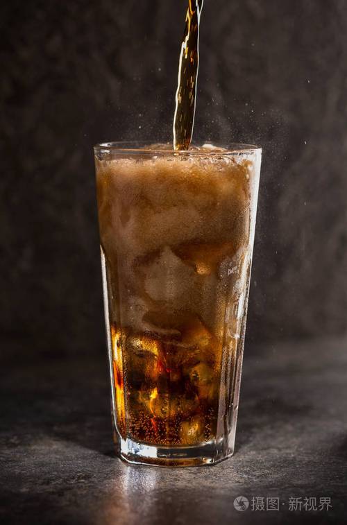 黑色背景上加冰块的一杯可乐碳酸饮料选择性fokus