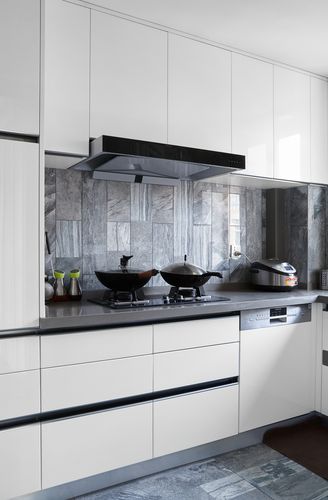 厨房用了白色橱柜加上天然大理石拼凑的墙面和地面,整个空间干净