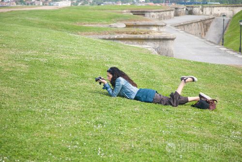 躺在草地上拍照的女人
